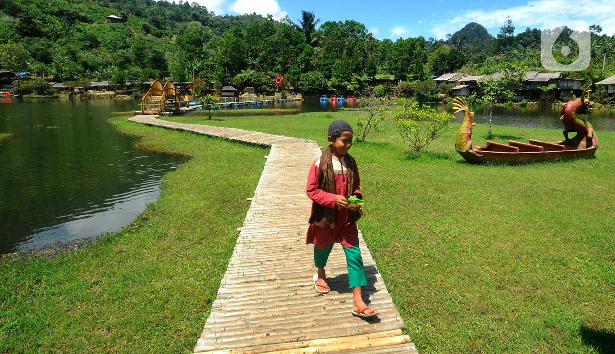 Wisatawan menikmati Situ Rawa Gede yang Instagrammable di kawasan Puncak Dua, Sukamakmur, Bogor, Jumat (6/1/2023). Meski kawasan Puncak Dua belum dikembangkan secara maksimal oleh Pemkab Bogor dan pemerintah pusat, warga seputar Jabodetabek dan Cianjur tetap antusias mengunjungi kawasan ini sebagai tempat wisata alternatif selain kawasan Puncak dan sekitarnya yang selalu didominasi kemacetan lalu lintas. (merdeka.com/Arie Basuki)