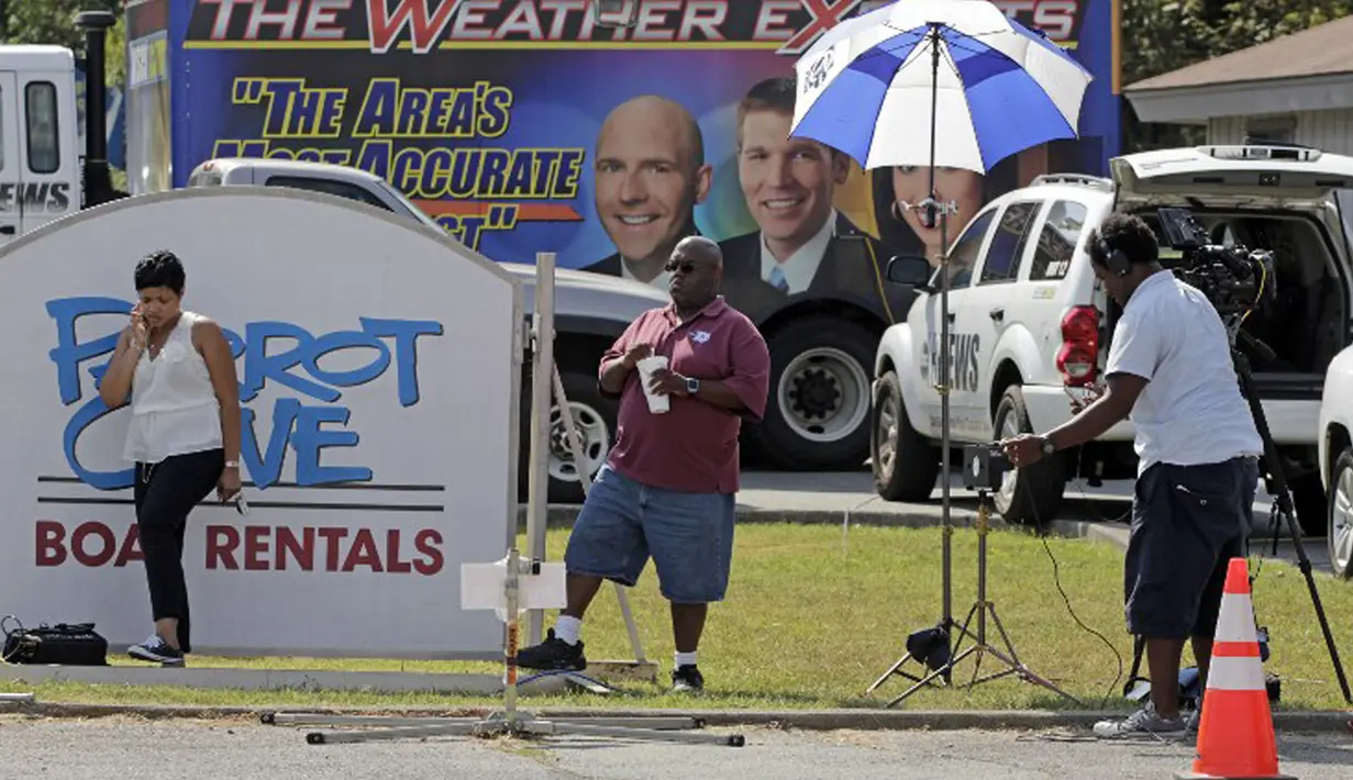 Sejumlah kru stasiun televisi melakukan penyiaran di lokasi penembakan di luar Bridgewater Plaza, Virginia, Rabu (26/8). Dua jurnalis WDBJ TV tewas ditembak mantan reporternya saat siaran langsung. (Jay Paul/Getty Images/AFP)