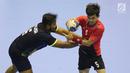 Pemain bola tangan Indonesia, Fitra Agung Aditya P (kanan) mencoba lolos dari kawalan pemain Malaysia pada penyisihan grup 3 bola tangan Asian Games 2018 di GOR PP POPKI, Jakarta, Minggu (26/8). Indonesia unggul 31-22. (Liputan6.com/Helmi Fithriansyah)