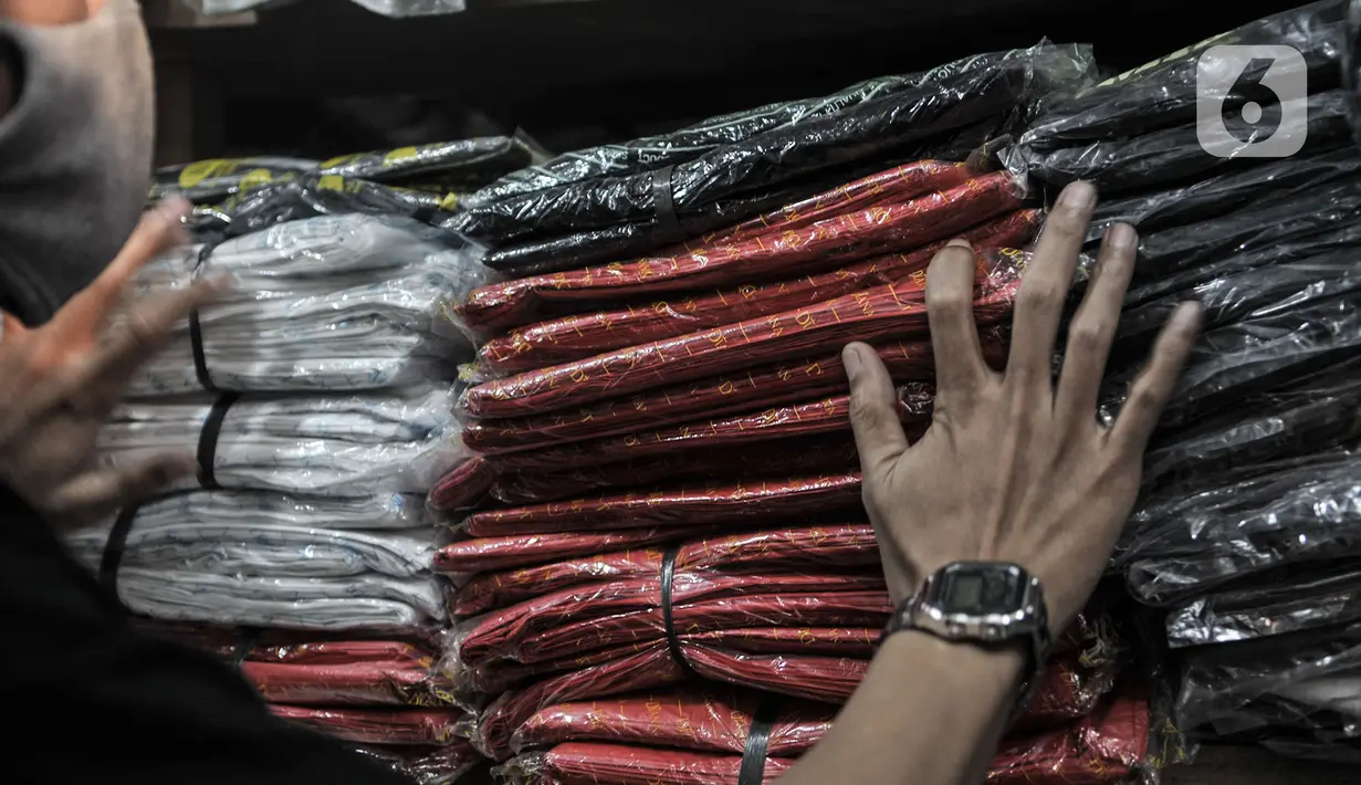 Abdullah (37) merapikan kantong plastik sekali pakai yang dijualnya di Pasar Tebet Barat, Jakarta, Selasa (30/6/2020). Jelang pemberlakuan larangan penggunaan plastik sekali pakai, Abdullah mengaku penjualan kantong kresek di tokonya menurun hingga 30 persen. (merdeka.com/Iqbal S Nugroho)