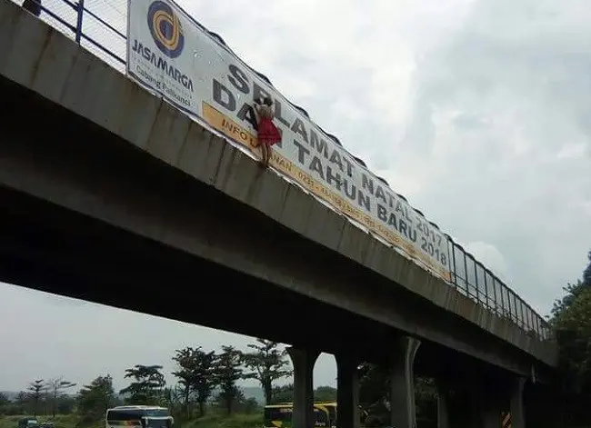 Siswi SMP itu menggantung di pinggir jembatan meski kakaknya sudah membujuknya.  (Liputan6.com/Panji Prayitno)