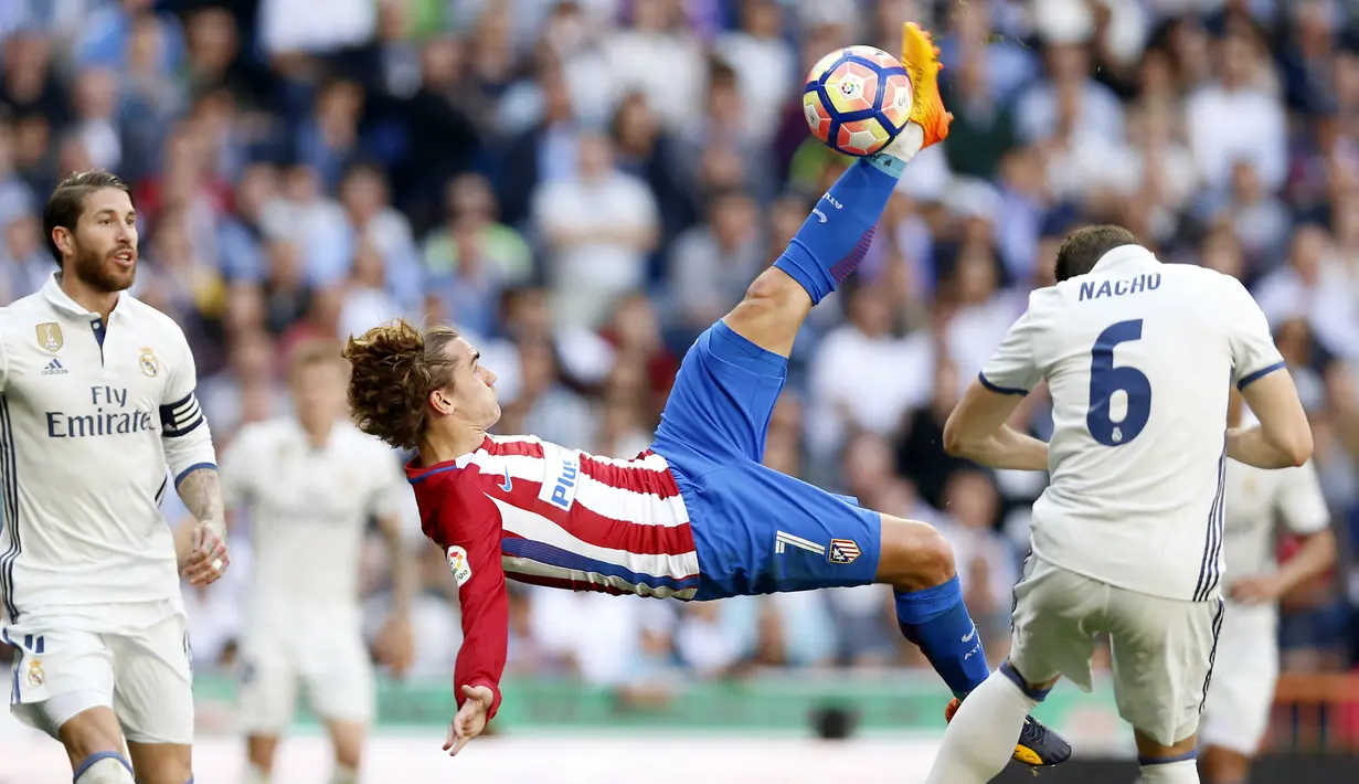 Pemain Atletico Madrid, Antoine Griezmann (tengah) melakukan tendangan salto ke gawang Real Madrid pada laga La Liga di Santiago Bernabeu stadium, Madrid, (8/4/2017). Real Madrid bermain Imbang 1-1 dengan Atletico.(AP/Daniel Ochoa de Olza)