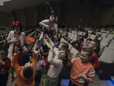 Para badut bermain dengan anak-anak pengungsi Ukraina di pusat bantuan regional di Pusat Kongres Praha di Praha, Republik Ceko (7/3/2022). Meskipun Ceko tidak berbatasan langsung dengan Ukraina, pengungsi dari Ukraina kini mulai berdatangan ke Negara itu. (AFP/Michal Cizek)