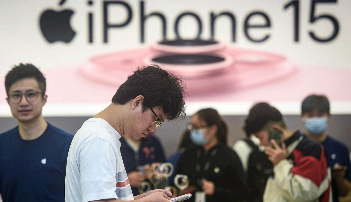 Seorang pria mencoba ponsel iPhone 15 yang baru saja diluncurkan di sebuah toko Apple di Hangzhou, di provinsi Zhejiang, China pada 22 September 2023. (AFP/China OUT)