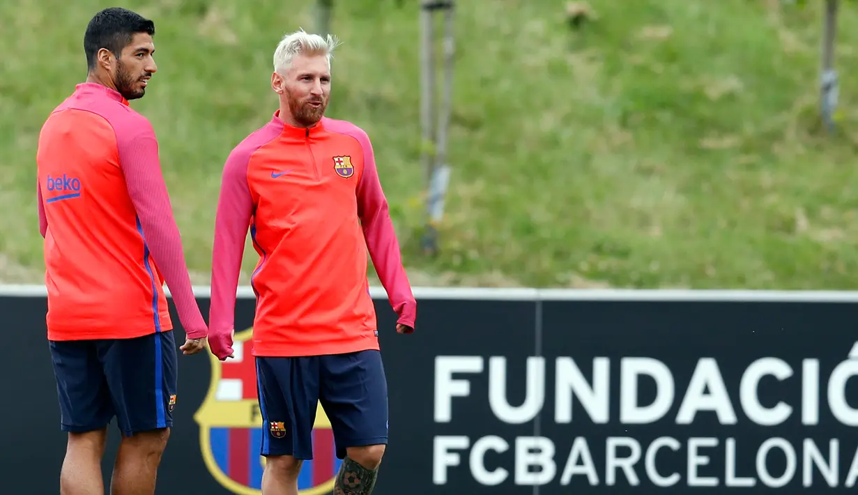 Penyerang Barcelona, Lionel Messi (kanan) dan Luis Suarez saat latihan bersama rekan setim di St Georges Park National Football Centre, Inggris, Senin (25/7). Messi tampil beda dengan rambut warna pirang. (REUTERS/ Darren Staples)