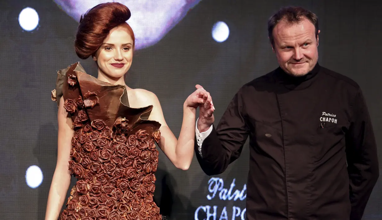 Seorang model memperagakan busana yang terbuat dari cokelat, kreasi desainer asal Perancis, Maitre Chocolatier Patrice Chapon (kanan) saat pameran cokelat internasional "Salon du Chocolat" di Milan, Italia, Jumat (12/2/2016). (REUTERS/ Stefano Rellandini)