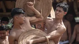 Penduduk desa mengambil bagian dalam ritual tahunan "Perang Pandan" " (pertarungan daun Pandan), yang secara lokal dikenal sebagai "Mekare-kare," untuk menghormati Indra, dewa perang Hindu, di Tenganan Pegringsingan, Bali pada Kamis 11 Juni 2026. (LANA PRIATNA/AFP)