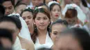 Ekspresi seorang wanita saat bersiap mengikuti pernikahan massal sebagai bagian dari perayaan Hari Valentine di Manila, Filipina (14/2). Sekitar 200 pasangan dilaporkan ikut serta dalam acara tersebut. (AFP Photo/Ted Aljibe)