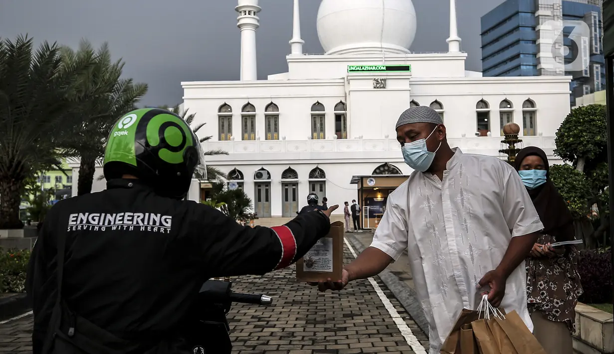 Petugas membagikan takjil kepada pengendara secara drive thru di Kompleks Masjid Al-Azhar, Jakarta, Kamis (15/4/2021). Pengelola masjid menyiapkan 500 bungkus takjil setiap harinya untuk pengendara yang dibagikan dengan sistem drive thru untuk mencegah penyebaran COVID-19. (Liputan6.com/Johan Tallo)