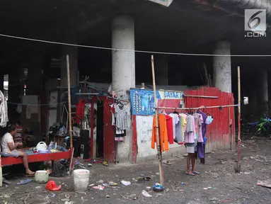 Warga beraktivitas di permukiman kolong Jalan Tol Pelabuhan, Tanjung Priok, Jakarta, Senin (23/4). Mahalnya harga hunian di Ibu Kota membuat mereka tinggal di kawasan tersebut meski dengan kondisi lingkungan kumuh dan kotor. (Liputan6.com/Arya Manggala)
