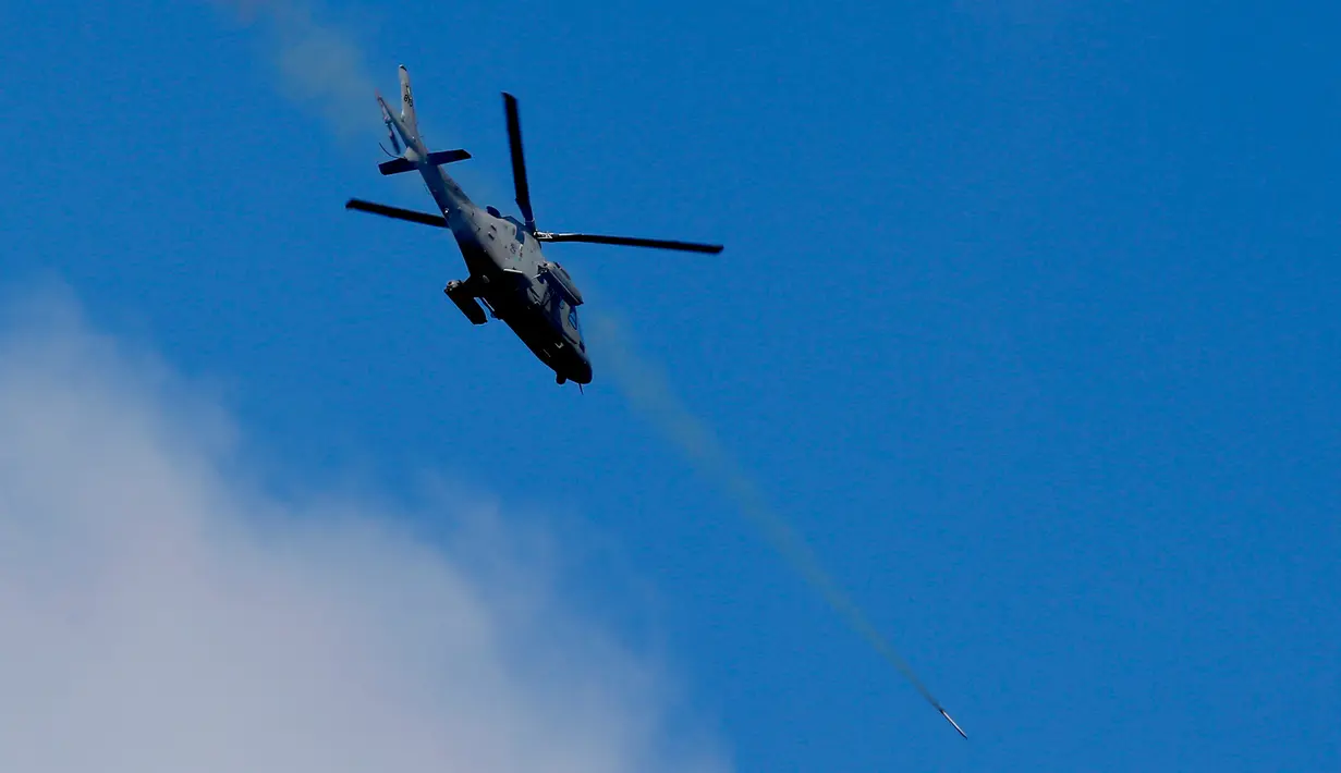 Sebuah helikopter tempur menembakkan sebuah roket ke militan maute di kota Marawi, Filipina Selatan (28/5). Pasukan Filipina melancarkan serangan udara pada hari Minggu untuk mengusir militan yang terkait dengan kelompok ISIS. (AP Photo/Bullit Marquez)