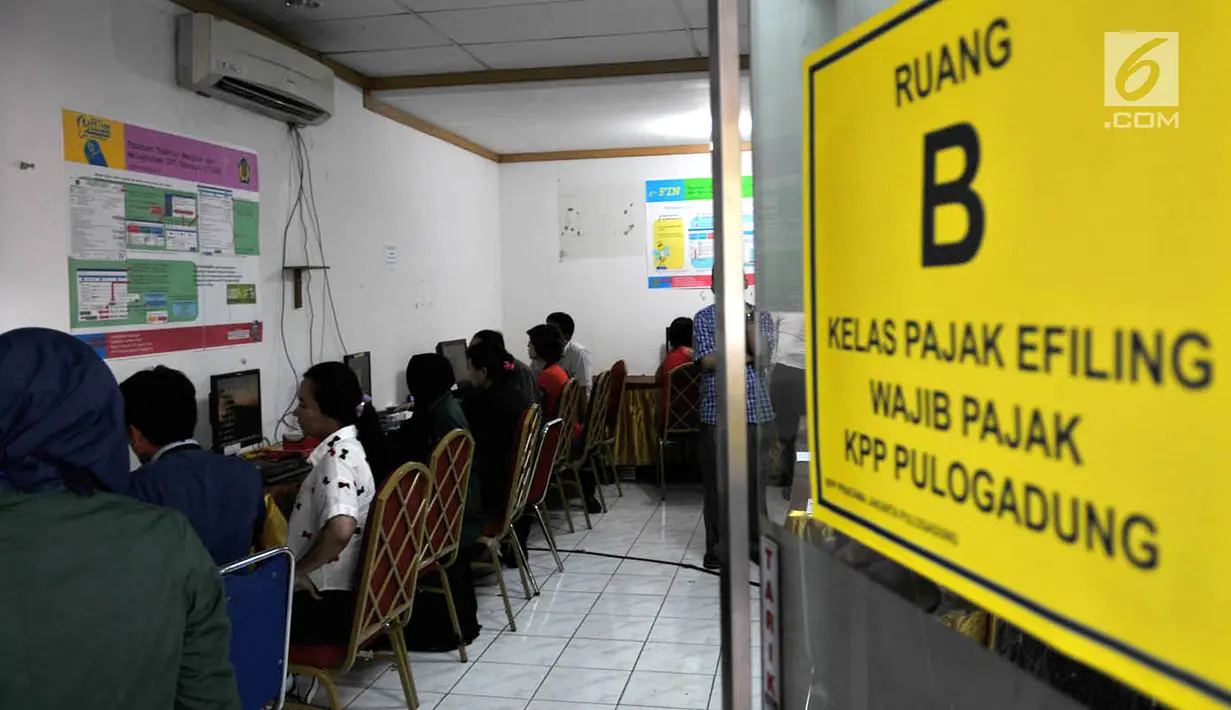 Wajib pajak dibantu petugas mengisi data di ruang Kelas Pajak EFILING di Kantor Pelayanan Pajak Pratama Jakarta, Kamis (29/3). Lonjakan wajib pajak terjadi jelang batas akhir penyampaian laporan SPT PPh orang pribadi. (Merdeka.com/Iqbal Nugroho)