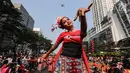 Seorang penari diikuti ribuan peserta membawakan Tari Kembang Jatoh dari Betawi saat CFD di Senayan, Jakarta, Minggu (12/8). Kegiatan ini digelar menyambut HUT Ke-73 RI dan Asian Games 2018. (Liputan6.com/Fery Pradolo)