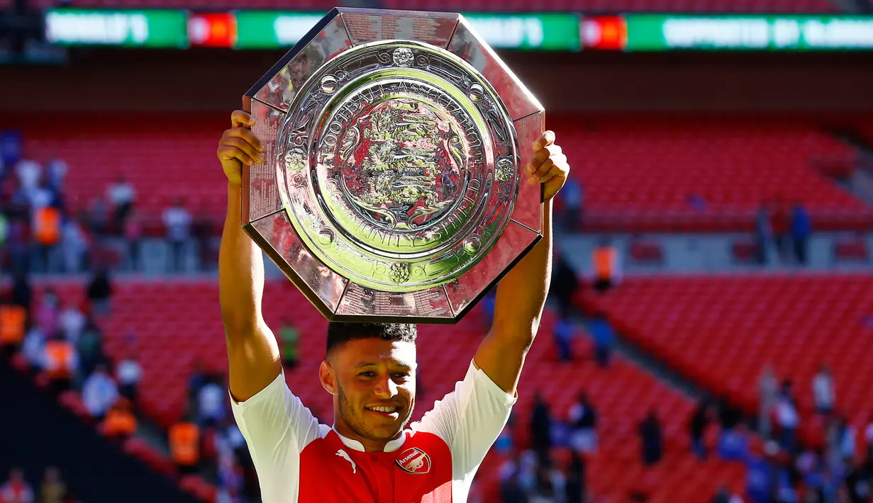 Gelandang Arsenal, Alex Oxlade Chamberlain mengangkat trofi Community Shield di Wembley Stadium, Minggu (2/8/2015). Arsenal menang atas Chelsea dengan skor 1-0. (Reuters/Dylan Martinez)