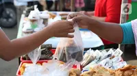 Warga melakukan aktivitas jual beli makanan untuk berbuka puasa (takjil) di kawasan Jalan Panjang, Jakarta, Selasa (5/5/2020). Pandemi virus COVID-19 dan pelaksanaan Pembatasan Sosial Berskala Besar (PSBB) berimbas pada sepinya pembeli takjil di kawasan tersebut. (Liputan6.com/Helmi Fithriansyah)