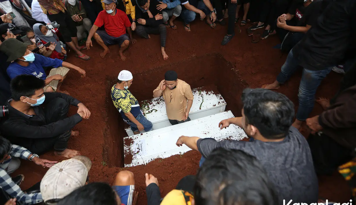 Pihak keluarga sepertinya tak ingin memisahkan keduanya yang selama ini dikenal saling mencinta dan membutuhkan. Peti jenazah Bibi diturunkan terlebih dahulu sebelum sang istri menyusulnya. (Kapanlagi.com/Budi Santoso)