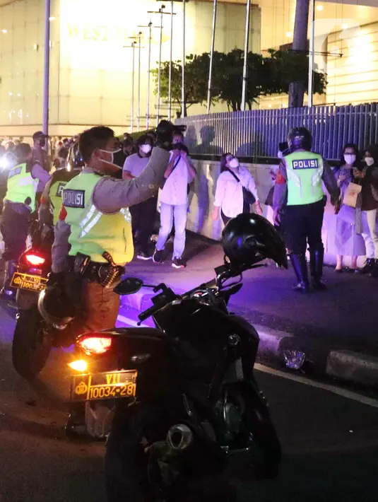 Polisi melakukan pembubaran terhadap warga yang berkerumun di kawasan Bundaran HI, Jakarta, Jumat (31/12/2021). Untuk mencegah penyebaran COVID-19, petugas gabungan melakukan pembubaran aktivitas warga di malam Tahun Baru. (Liputan6.com/Angga Yuniar)