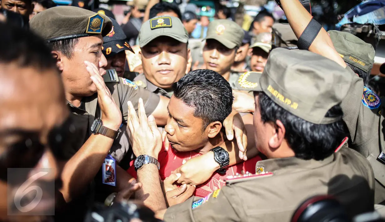 Seorang provokator diamankan petugas dalam penertipan PKL di kawasan Stasiun Kota Tua, Jakarta, Selasa (25/10). Dalam penertipan tersebut pedagang melawan dikarenakan mereka telah membayar iuran setiap harinya  ke petugas. (Liputan6.com/Faizal Fanani)