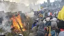 Demonstran membakar pohon di luar gedung parlemen di Quito (8/10/2019). Unjuk rasa ini telah berlangsung selama beberapa hari dan diikuti berbagai elemen termasuk masyarakat adat. (AFP Photo/Martin Bernetti)