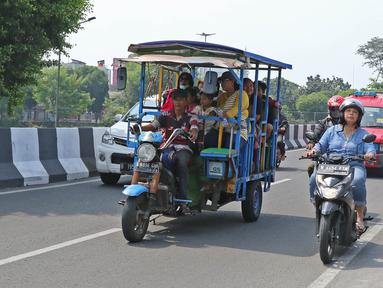 Sejumlah warga menaiki bak terbuka motor roda tiga menuju Kebun Binatang Ragunan di kawasan Jakarta, Minggu (9/6/2019). Selain melanggar aturan lalu lintas, perilaku tersebut juga sangat membahayakan keselamatan penumpang. (Liputan6.com/Herman Zakharia)