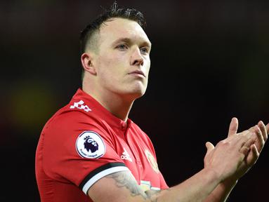 Pemain Manchester United, Phil Jones memberikan aplaus kepada penonton setelah mengalahkan Bournemouth dalam pertandingan lanjutan Liga Inggris 2012/2013 di Old Trafford, Rabu (13/12/2017). Phil Jones secara resmi akan pamit meninggalkan Old Trafford musim 2022/2023 setelah 12 tahun mengabdi. (AFP/Oli Scarff)
