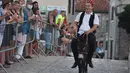 Seorang pria menunggangi keledai dalam kompetisi balap keledai tradisional ke-53 di Tribunj, Kroasia (29/8/2020). (Xinhua/Pixsell/Hrvoje Jelavic)