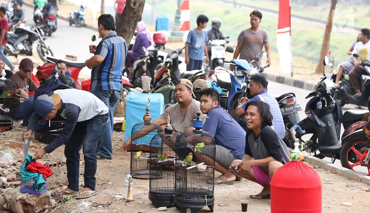 Peserta mengikuti lomba kicau burung di kawasan Kanal Banjir Timur, Jakarta, Rabu (29/8). Lomba yang diadakan komunitas pecinta burung itu menarik perhatian warga serta pengendara yang melintas di kawasan tersebut. (Liputan6.com/Immanuel Antonius)