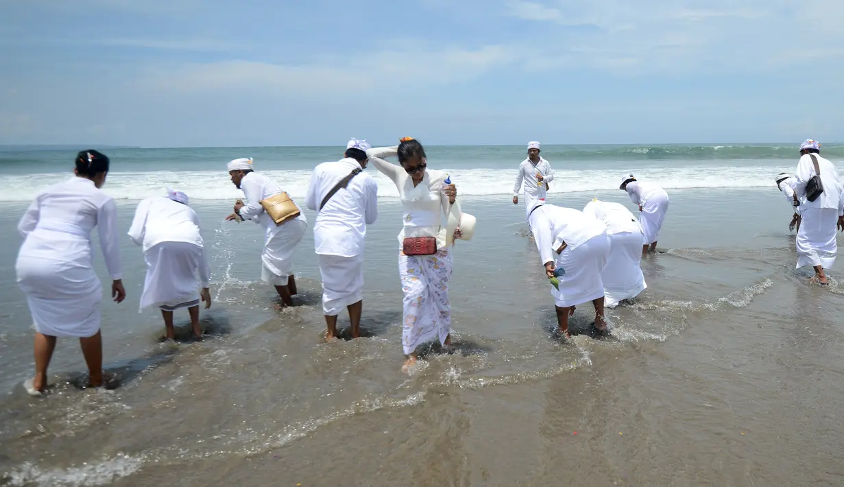 Umat Hindu melarung sesaji ke laut saat menggelar ritual Melasti di Pantai Petitenget, Denpasar, Bali, Senin (4/3). Gunungan sesaji terdiri dari buah-buahan dan sayuran. (SONNY TUMBELAKA/AFP)