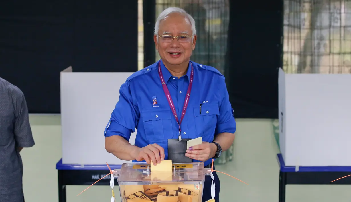 Perdana Menteri Malaysia, Najib Razak memasukkan surat suara ke kotak saat pemilihan umum (Pemilu) di TPS wilayah Pekan, Pahang, Rabu (9/5). Pemilu ini pertarungan antara PM Najib yang sudah berkuasa sejak 2009, melawan Mahathir Mohamad. (AP/Aaron Favila)