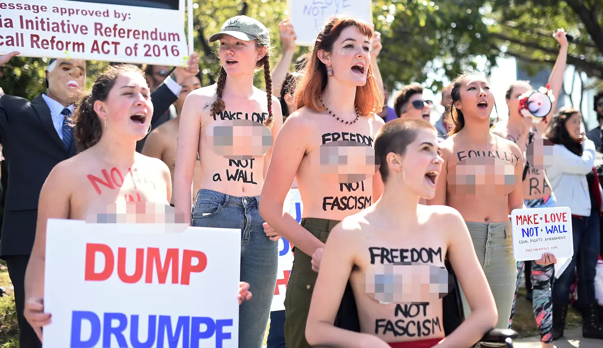 Sejumlah wanita bertelanjang dada sambil membawa poster tuntutan saat menggelar demo menolak Donald Trump di Burlingame, California (29/4). Para wanita ini menolak Donald Trump menjadi Presiden Amerika Serikat. (REUTERS/Noah Berger)