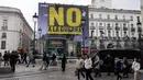 Perdana Menteri Spanyol Pedro Sanchez, Rabu (4/3/2026), dengan tegas menyatakan menolak tunduk terhadap eskalasi militer di Timur Tengah dan tetap menyerukan gencatan senjata segera antara Israel, Amerika Serikat (AS), dan Iran. Tampak dalam foto, para pejalan kaki berjalan saat para aktivis Greenpeace membentangkan spanduk besar bertuliskan "Tidak untuk Perang" sebagai bentuk protes terhadap serangan Amerika Serikat (AS) dan Israel terhadap Iran, di Lapangan Puerta del Sol, Madrid, Spanyol, pada Selasa 10 Maret 2026. (Paul Hanna/AFP)