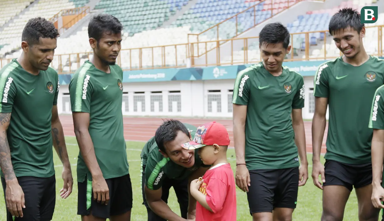 Pemain Timnas Indonesia, Hansamu Yama, menyapa anak pasien kanker saat latihan di Stadion Wibawa Mukti, Jawa Barat, Senin (5/11). Pemusatan latihan Timnas ini merupakan persiapan jelang Piala AFF 2018. (Bola.com/M Iqbal Ichsan)
