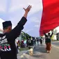 Sejumlah santri dari Pondok Pesantren Ashabul Kahfi membawa bendera Merah Putih besar saat mengikuti pawai Hari Santri Nasional 2017 di Gunungpati, Semarang (22/10). (Liputan6.com/Gholib)