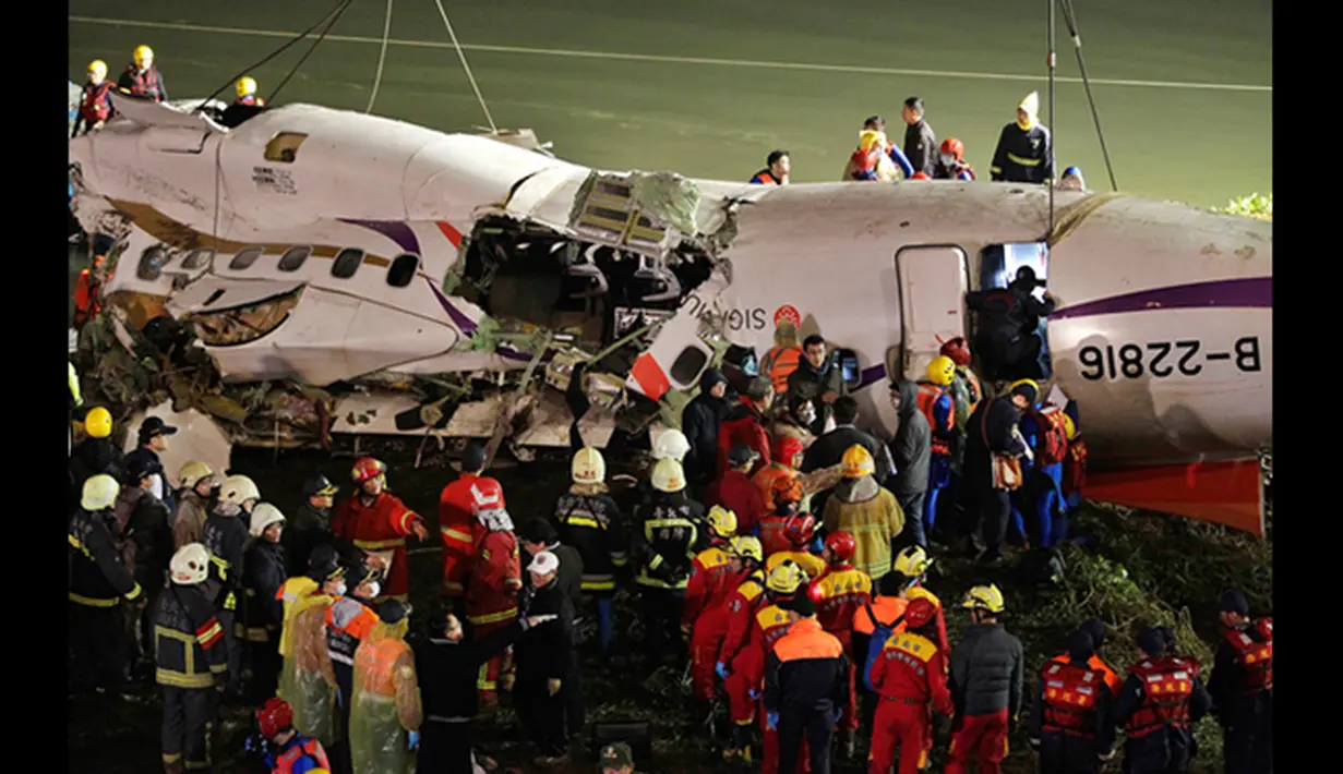 Petugas berusaha mengangkat badan pesawat TransAsia Airways turboprop ATR 72-600 di sungai Taipe, Taiwan, Rabu (4/2/2015).  Pesawat yang mengangkut 58 penumpang dan awak pesawat itu terhempas ke sungai saat hendak lepas landas. (REUTERS/Pichi Chuang)