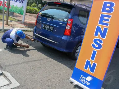 Petugas melakukan uji emisi gas buang sebuah mobil di Taman Mataram Blok M, Jakarta, Selasa (23/9/14).  (Liputan6.com/Faizal Fanani)