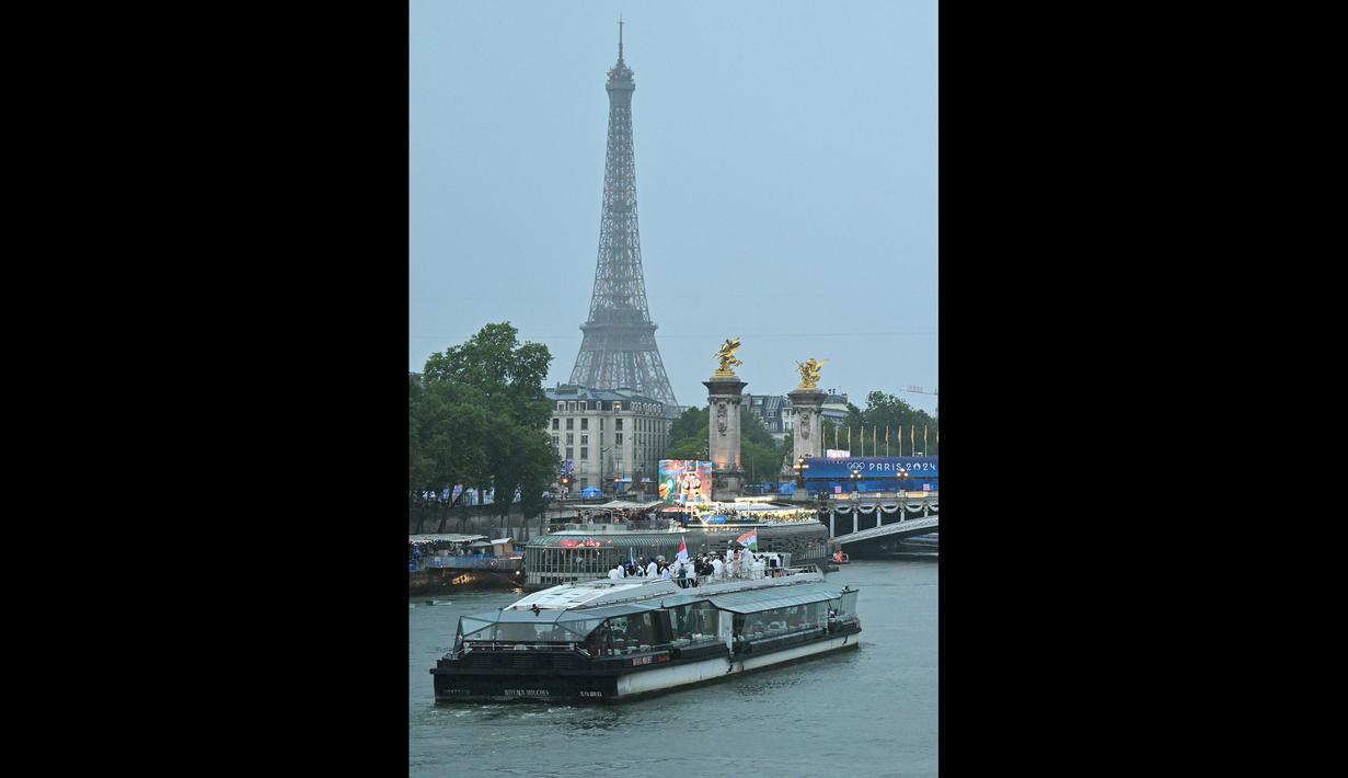 Kontingen Indonesia bersama kontingen India dan Iran berlayar di atas perahu saat upacara pembukaan Olimpiade Paris 2024 di Sungai Seine, Paris Prancis, 26 Juli 2024. (AFP/Andrej Isakovic)