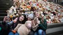Siswa berswafoto sebelum meletakkan boneka beruang atau Teddy Bears di tangga Concert Hall, Berlin, Kamis (15/3). 740 boneka itu dipajang di tengah kegiatan Organisasi Visi Dunia yang memiliki tujuan misi kemanusiaan. (AFP PHOTO/Odd ANDERSEN)