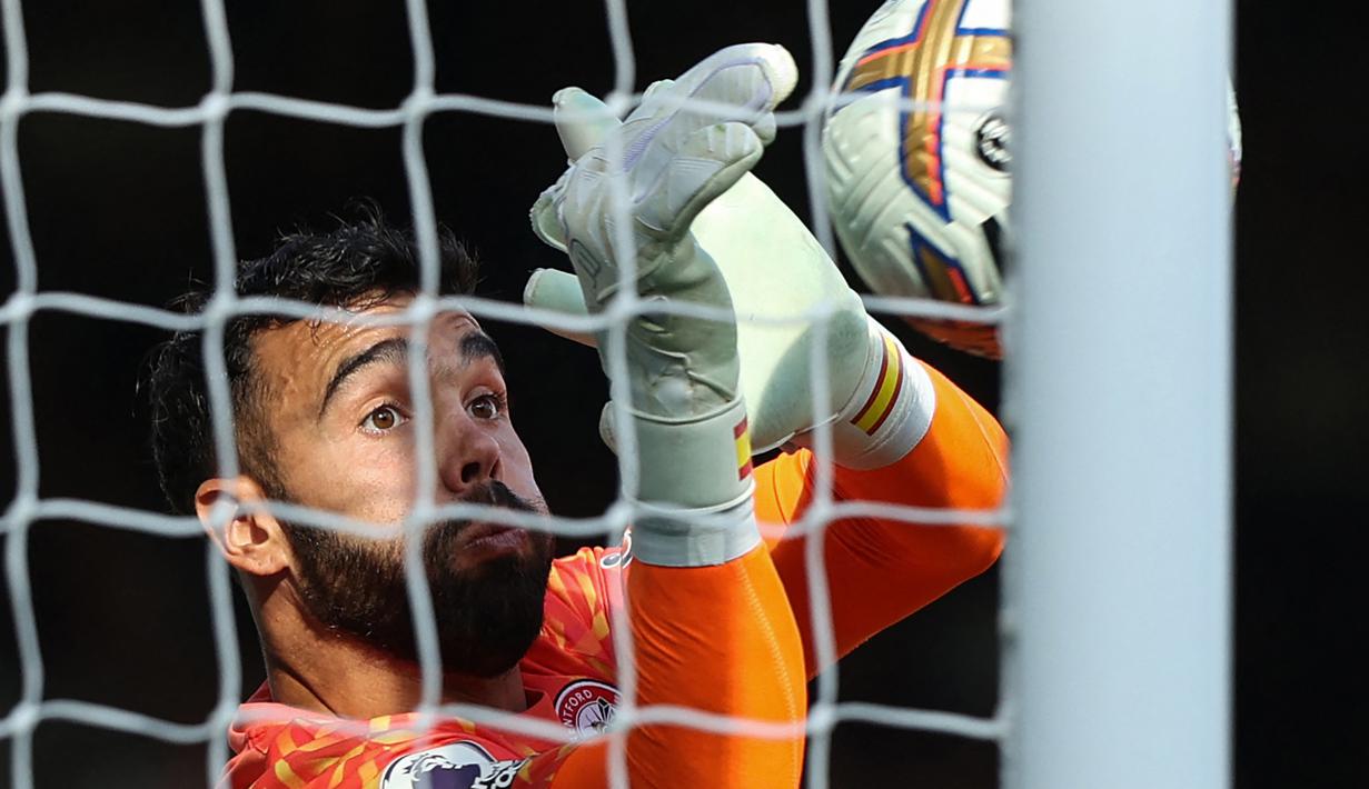 Kiper Brentford, David Raya berhasil menangkap bola saat menghadapi Fulham pada laga Liga Inggris 2022/2023 di Craven Cottage, London (20/8/2022). Namun Manchester United akhirnya memimpin persaingan untuk mendapatkan David Raya yang kini berusia 27 tahun, setelah Tottenham Hotspur terganjal harga yang dipatok Brentford yang mencapai 40 juta poundsterling karena dinilai terlalu mahal. (AFP/Adrian Dennis)