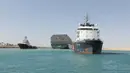 Kapal kargo Ever Given ditemani kapal tunda saat melaju di Terusan Suez, Mesir, Senin (29/3/2021). Ini adalah salah satu rute perdagangan tersibuk di dunia. (Suez Canal Authority via AP)