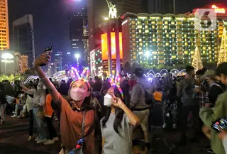 Warga memadati Car Free Night (CFN) pada malam pergantian tahun baru 2023 di kawasan Bundaran Hotel Indonesia, Jakarta, Sabtu (31/12/2022). Banyak warga yang berkumpul merayakan pergantian tahun baru sambil berswafoto, menikmati kuliner, berjalan hingga bersepeda santai. (Liputan6.com/Angga Yuniar)