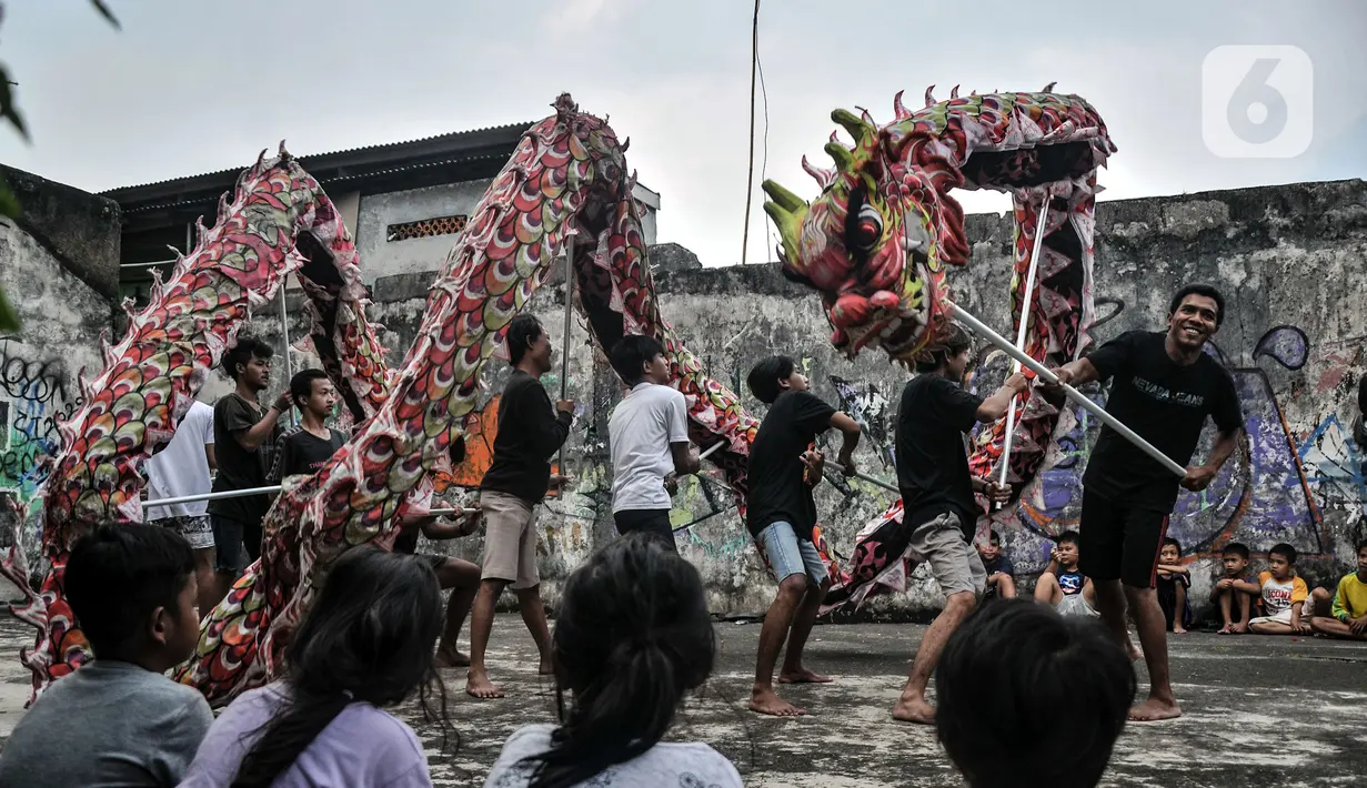 Anak-anak menyaksikan anggota Naga Merah Putih saat latihan Liong di kawasan Babakan Pasar, Bogor, Jawa Barat, Senin (17/1/2022). Jelang perayaan Tahun Baru Imlek, klub kesenian Tionghoa tersebut rutin melakukan latihan memainkan Liong dan Barongsai. (merdeka.com/Iqbal S. Nugroho)