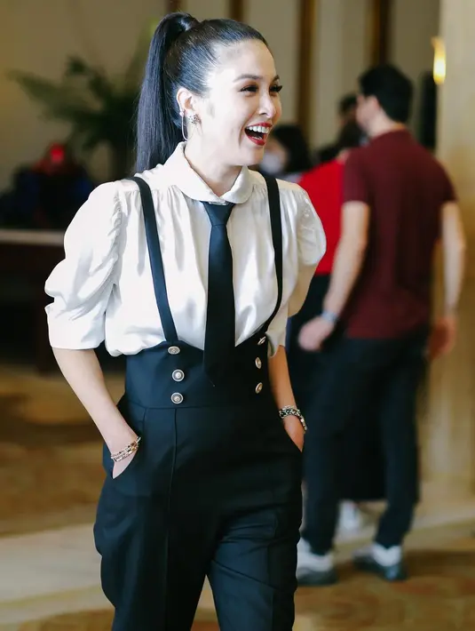 Sandra Dewi mengenakan blus warna putih yang dipadukan suspender overall dan dasi warna hitam senada lansiran @claie.ateliers by cynthiatan__. [@sandradewi88]