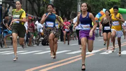 Peserta berlari menggunakan sepatu high heels saat acara"Tour De Takong" di Marikina, Manila, Filipina, 26 November 2016. Balap lari itu merupakan bagian dari festival sepatu tahunan di wilayah yang dikenal sebagai ibu kota sepatu. (REUTERS/Ezra Acayan)