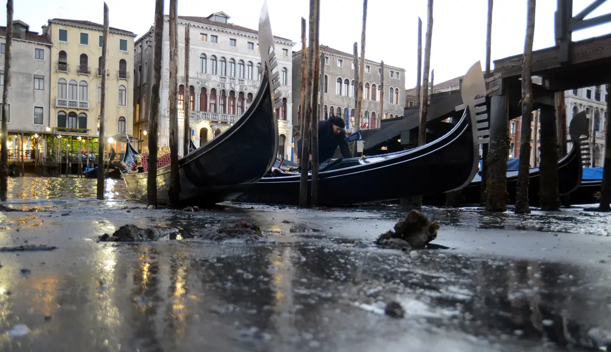 Perahu Gondola bersandar di laguna Venesia, Italia (29/12). Surutnya kanal ini mengakibatkan Gondola sulit berjalan dan banyak bersandar di pinggir Grand Canal di laguna Venesia, Italia. (REUTERS/Manuel Silvestri)