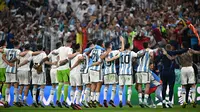 Pemain Argentina merayakan kemenangan di depan pendukungnya setelah berhasil mengalahkan Kroasia dengan skor 3-0 saat laga semifinal Piala Dunia 2022 yang berlangsung di Lusail Stadium, Qatar, Selasa (13/12/2022) waktu setempat. (AFP/Anne-Christine Poujoulat)