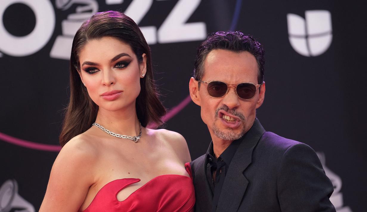 Marc Anthony bersama tunangannya model Paraguay Nadia Ferreira berpose saat tiba menghadiri penghargaan Grammy Latin ke-23 di Michelob Ultra Arena Mandalay Bay di Las Vegas, Nevada, pada 17 November 2022. Ferreira memukau penonton dalam gaun satin merah strapless yang terinspirasi Jessica Rabbit yang memeluk pinggang mungil dan pinggulnya yang indah. (AFP/Chris Delmas)