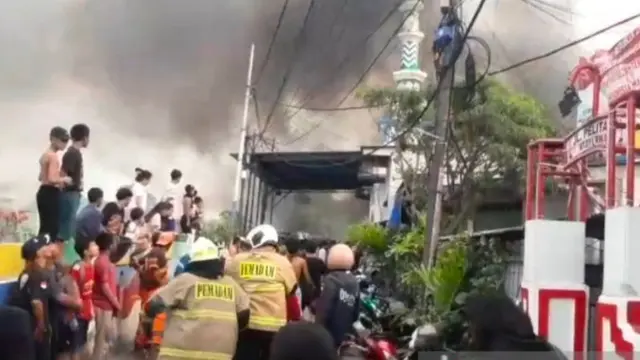 Asap hitam membumbung tinggi dari kebakaran rumah di Gang Pelita 10, Jalan Tomang Banjir Kanal, Jati Pulo, Palmerah, Jakarta Barat, pada Minggu (16/11/2025).