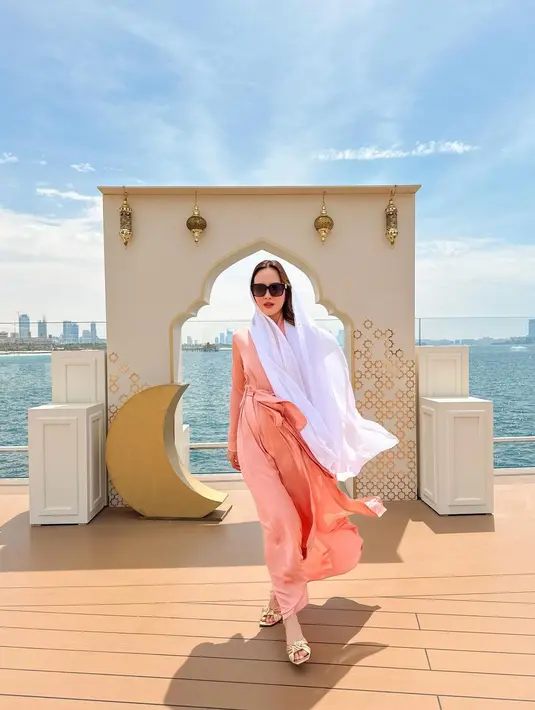 Penampilan yang cukup berbeda ketika Shandy Aulia berlibur ke Dubai. Di sini, Shandy Aulia tampil santun tertutup mengenakan dress pink panjang lengan panjang, dan syal putih yang menutupi kepalanya. [Foto: Instagram/shandyaulia]