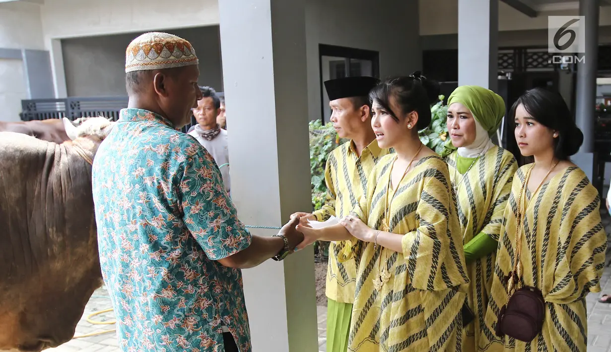 Penyanyi dangdut Ayu Ting Ting bersama keluarganya saat penyerahan hewan kurban di kediamannya kawasan Depok (1/9). Ayu juga turut melihat langsung proses penyembelihan bersama keluarganya. (Liputan6.com/Herman Zakharia)
