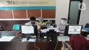 Petugas Dinas Kependudukan dan Catatan Sipil menggunakan pelindung wajah saat melayani warga di Kecamatan Pamulang, Tangerang Selatan, Rabu (3/6/2020). Sejumlah kantor pelayanan pemerintah melaksanakan protokol kesehatan yang ketat untuk memutus rantai penyebaran covid-19. (merdeka.com/Arie Basuki)